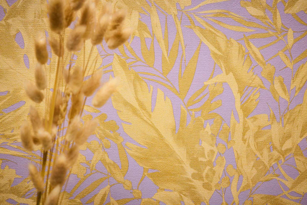 Violetas, okera lapas: Pasteļvioletas tapetes ar lielām okera dzeltenām tropu lapām retro stilā.