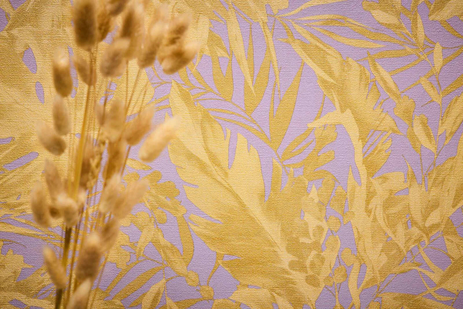 Violetas, okera lapas: Pasteļvioletas tapetes ar lielām okera dzeltenām tropu lapām retro stilā.
