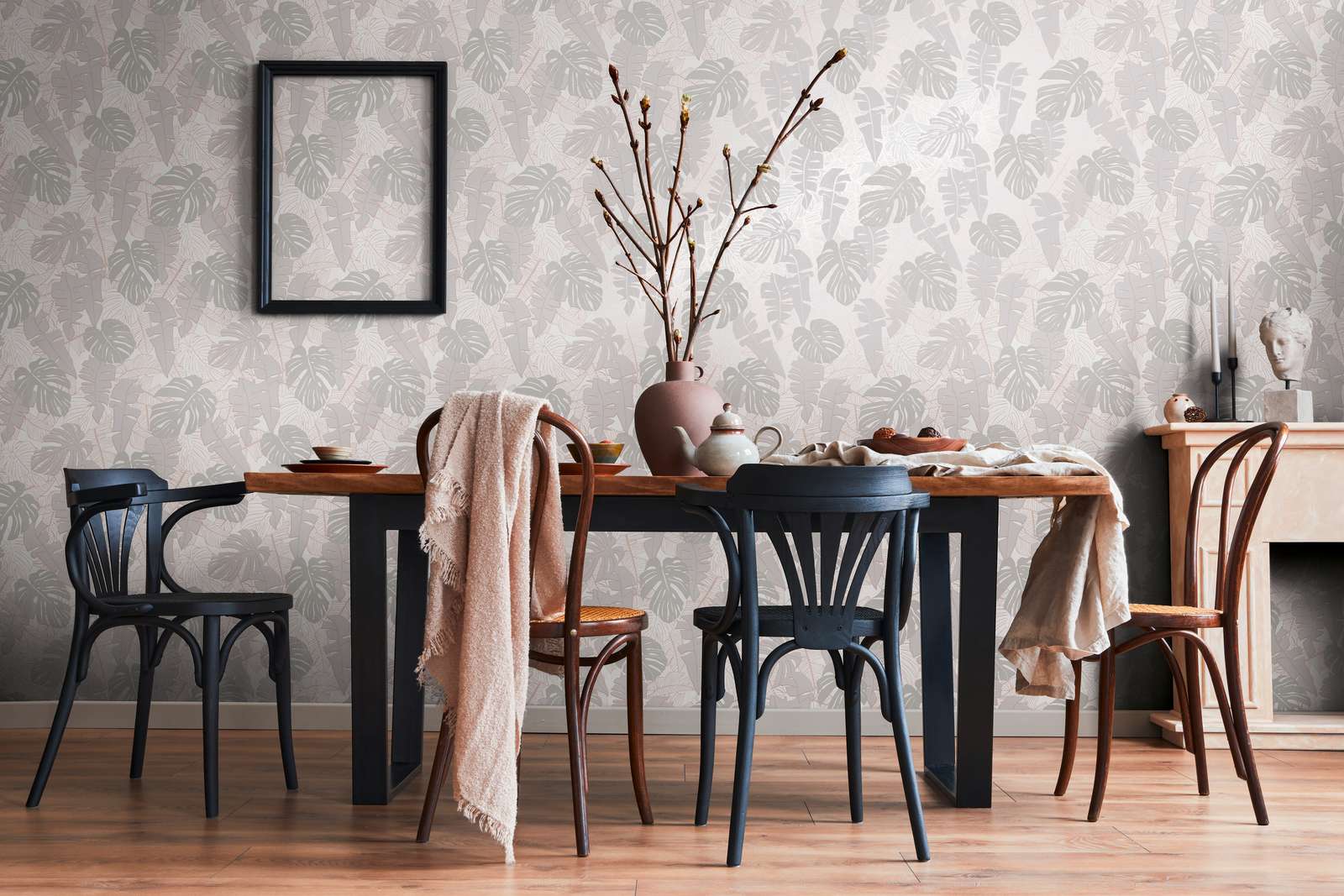 Tropu tapetes ar banānu lapām un metālisku efektu siltā pelēkā tonī - viesistabas interjerā