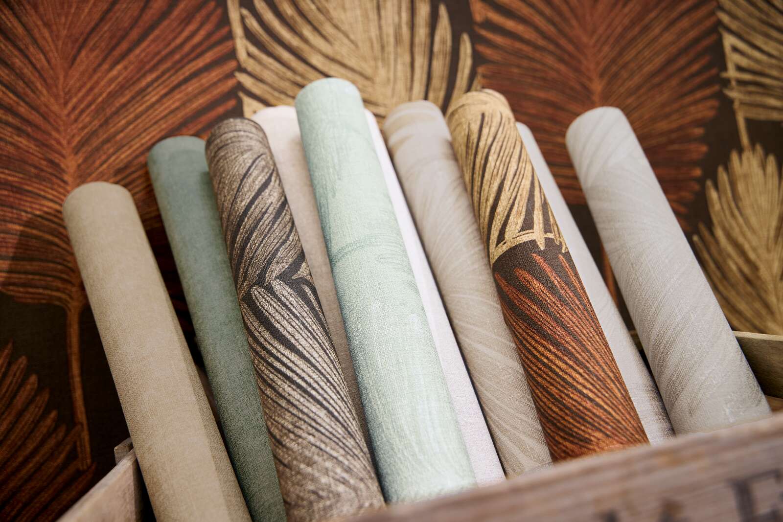 Eksotiska dizaina tapetes ar palmu lapām un faktūru brūnā tonī - idejas interjerām