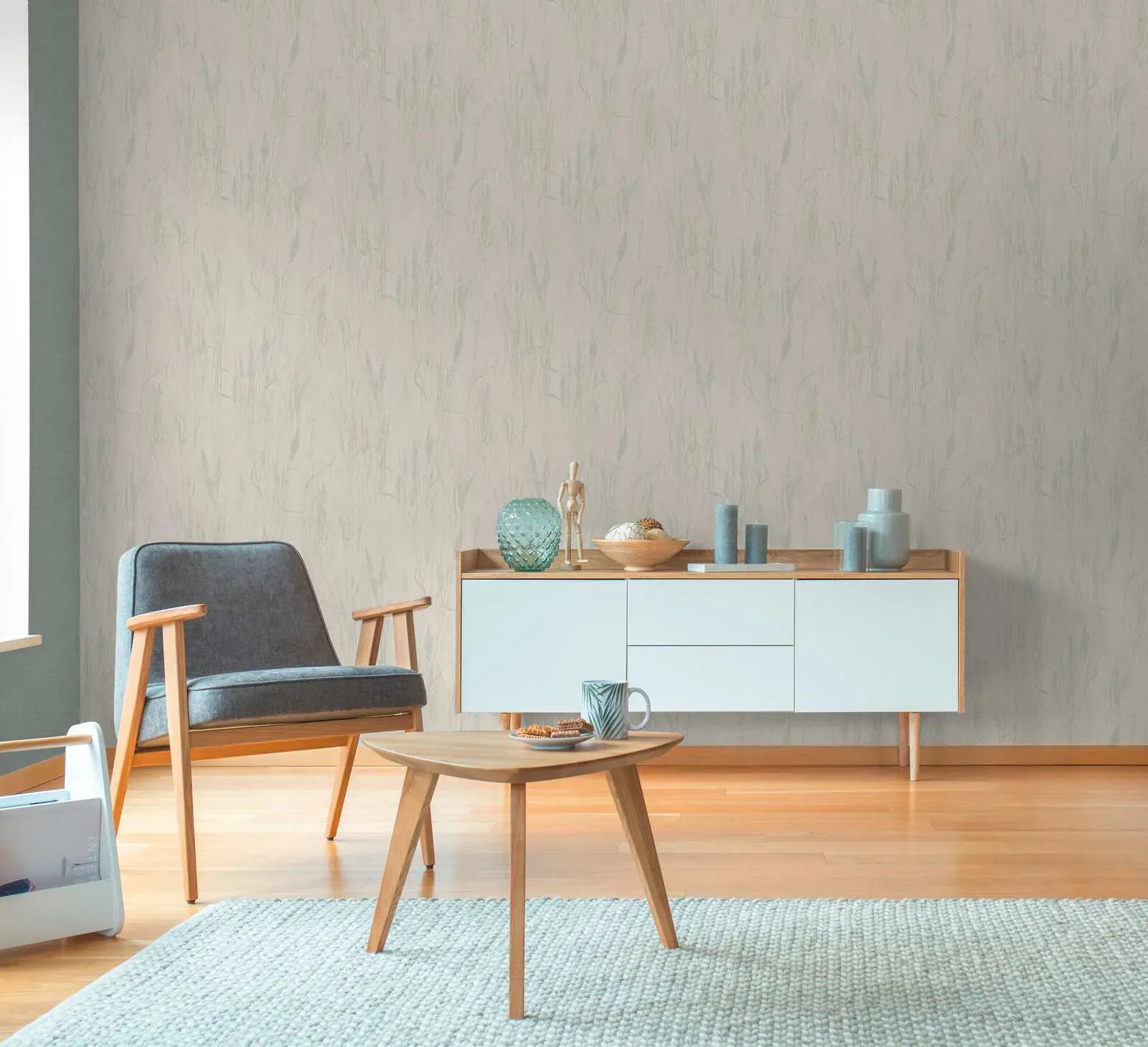 Pelēkas un zaļas neaustas tapetes ar filigrānu zāles rakstu harmoniskā viesistabas interjerā. SKU: 3010641, AS Creation.