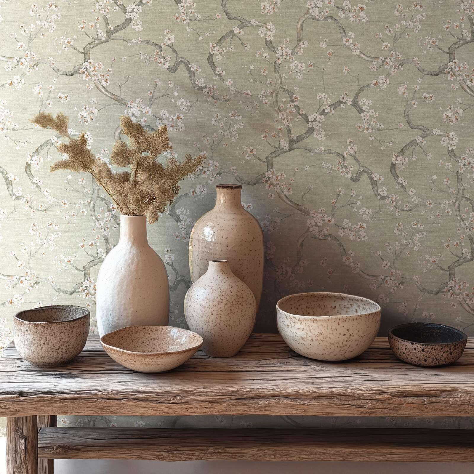 Zaļi pelēkas tapetes ar delikātu ķiršu ziedu rakstu un tekstūru - istabas interjerā