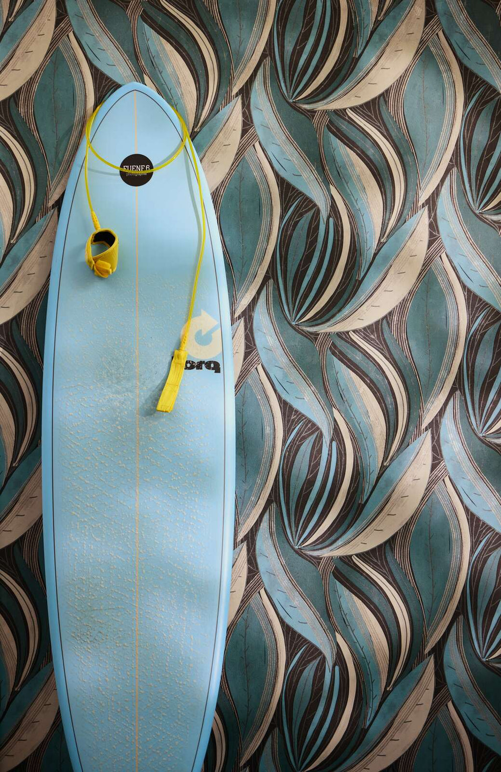 Dramatiskas tapetes ar tumšām lapām zilā un tirkīza gammā - viesistabas interjerā