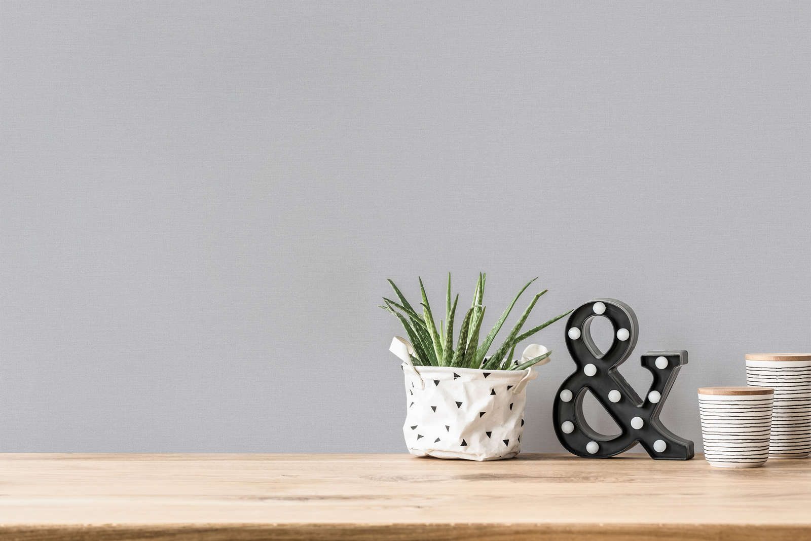 Pelēkas vienkrāsainas tapetes ar lina struktūru - viesistabas interjerā