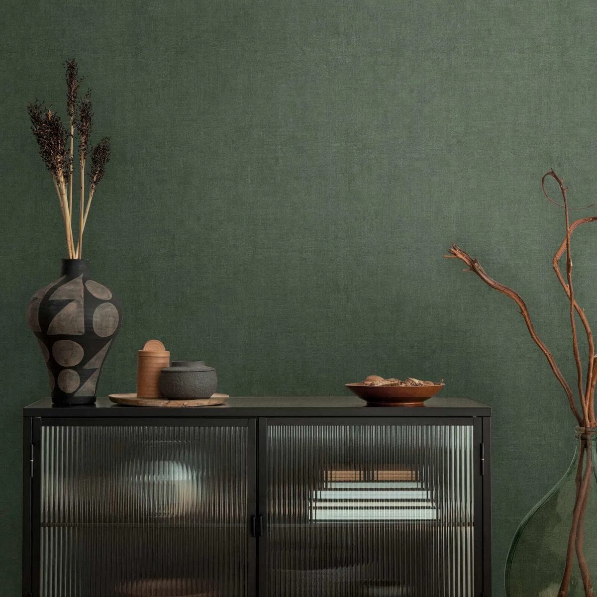 Tumši zaļas tapetes ar smalku auduma izskatu un mirdzumu drosmīgā guļamistabas interjerā. SKU: 3007660, AS Creation.